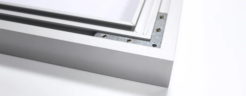Close-up of a silver aluminum frame with screws and layered inner panels on a white background.