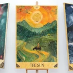 Three tarot cards on wooden easels: The Tower (left), The Sun (center), and The Moon (right).