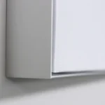 Close-up of a white boxed edge (likely a shelf or book) against a light gray background with a soft shadow underneath.