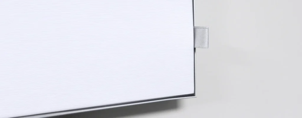 Close-up of a white textured cabinet drawer with a small silver pull handle on the side.
