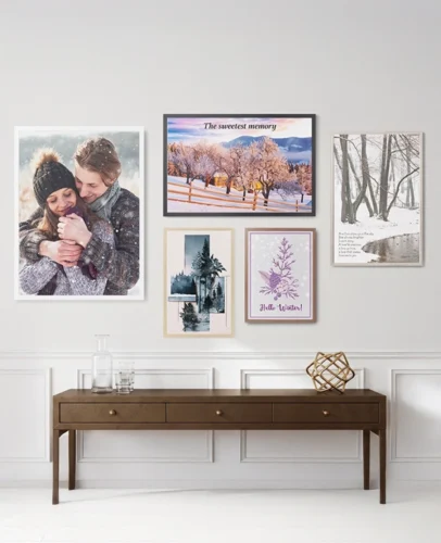 Wall gallery of framed photos and art above a wooden console table, including a snowy landscape and couple portrait actions.